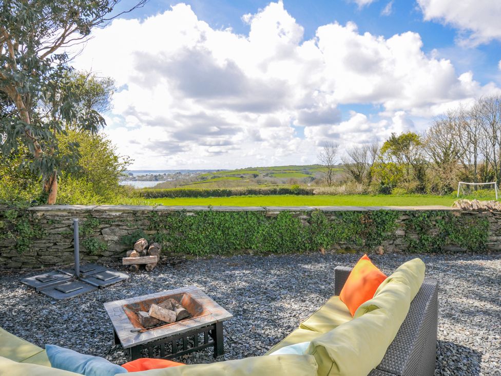 A garden with seating and a fire pit at The Cowshed in Portscatho