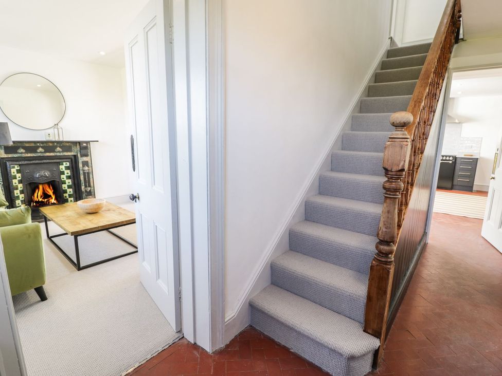 A living room with a staircase and fireplace at Ty Mawr Farm in Llanfairpwllgwyngyll