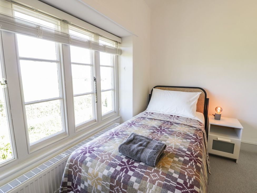 A bedroom with a single bed and a lamp on a nightstand at Ty Mawr Farm in Llanfairpwllgwyngyll