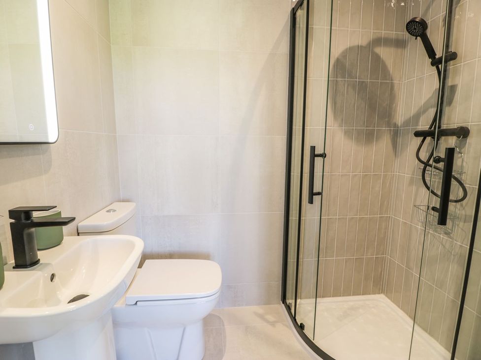 A bathroom with a sink, toilet, and shower at Ty Mawr Farm in Llanfairpwllgwyngyll