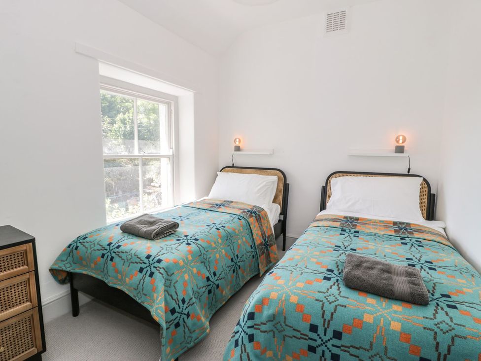 A bedroom with two beds and a window at Ty Mawr Farm in Llanfairpwllgwyngyll