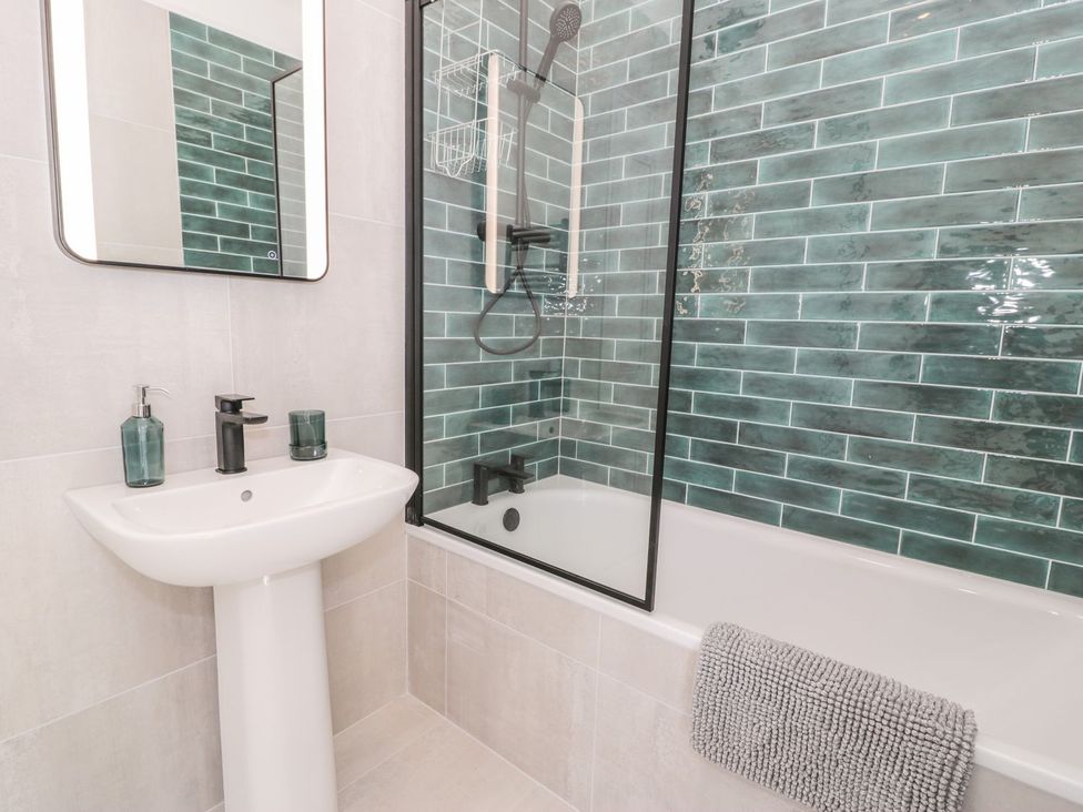 A bathroom with a sink, mirror, shower, and bathtub at Ty Mawr Farm Llanfairpwllgwyngyll