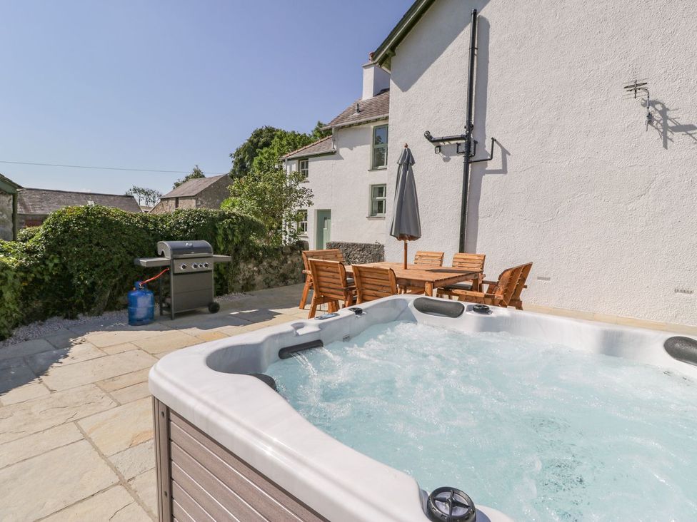 A garden with a hot tub and a dining area at Ty Mawr Farm Llanfairpwllgwyngyll