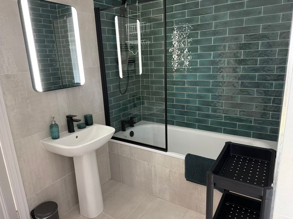 A bathroom with a bath tub and wash basin at Ty Mawr Farm in Penmynydd near Llanfairpwllgwyngyll