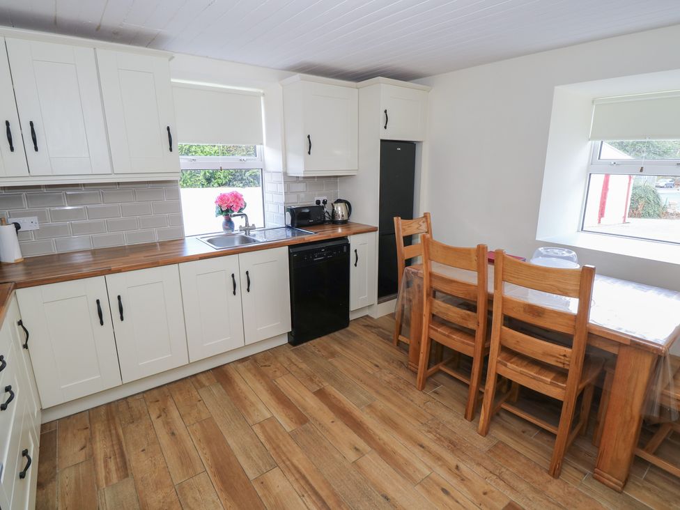 A kitchen with cabinets and a dining table at Greenfield House in Aughavas, County Leitrim