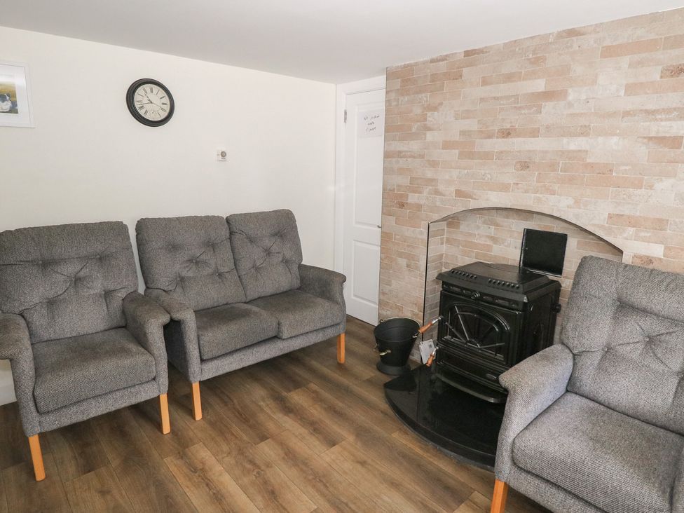 A snug with seating and a fireplace at Greenfield House Aughavas, County Leitrim