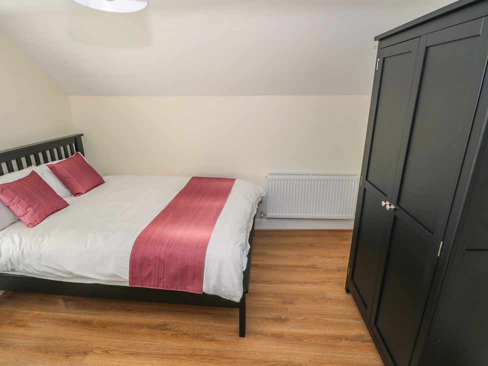 A bedroom with a bed and wardrobe at Greenfield House, Aughavas, County Leitrim
