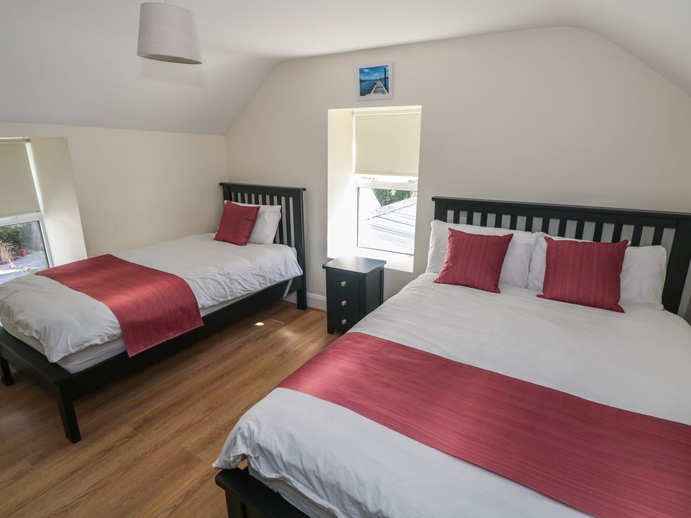 A bedroom with two beds and a nightstand at Greenfield House in Aughavas, County Leitrim