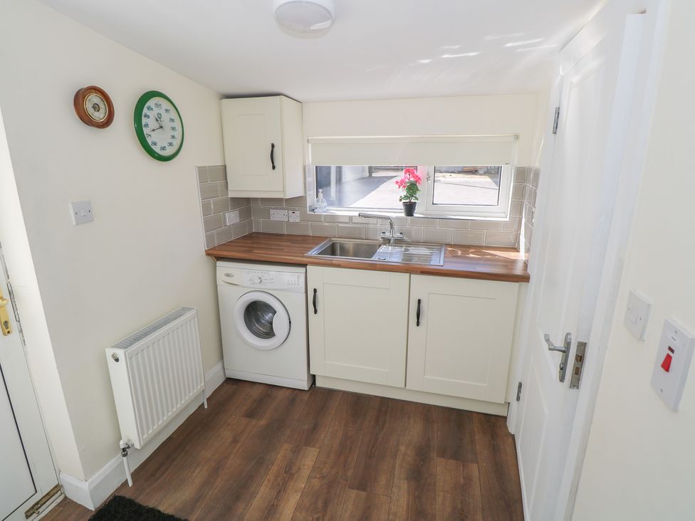 A kitchen with a sink and washing machine at Greenfield House in Aughavas, County Leitrim