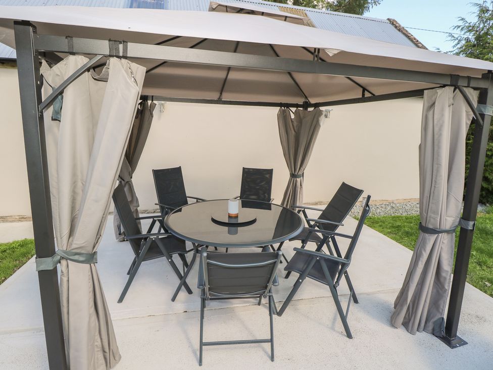 An outdoor seating area with a gazebo and table at Greenfield House Aughavas, County Leitrim