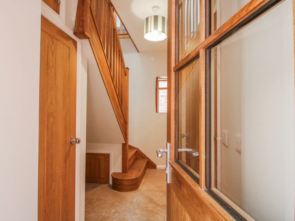 A hallway with a staircase and storage at The Old China Shop in Ludlow