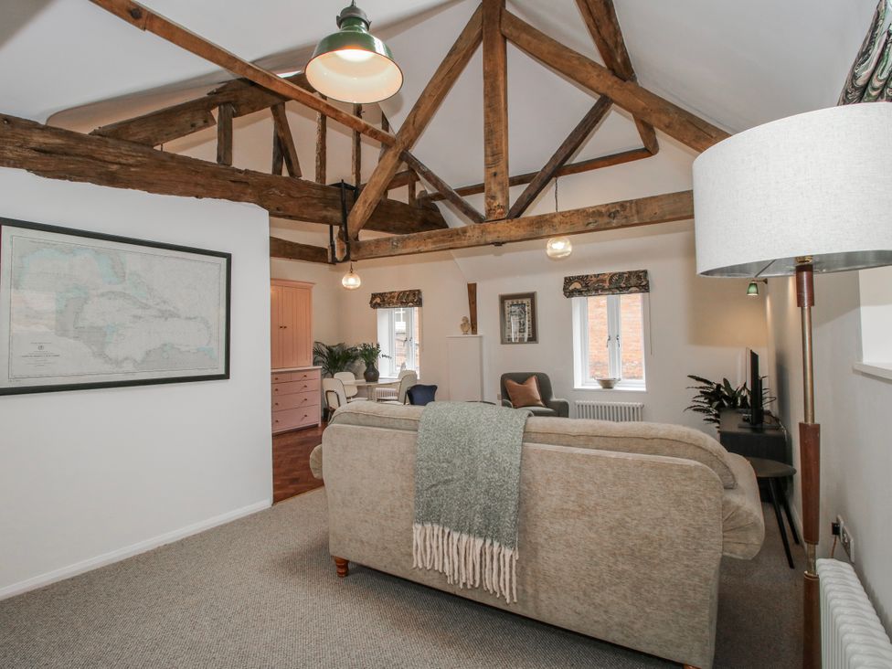 A living room with a sofa and dining table at The Old China Shop in Ludlow