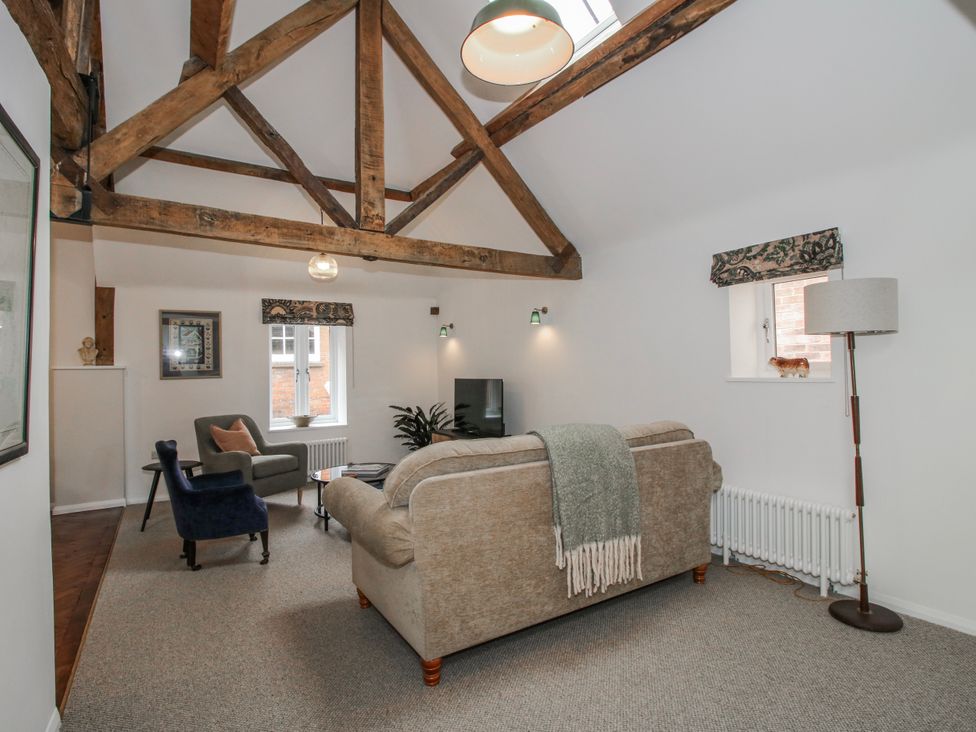 A living room with a sofa and armchair at The Old China Shop in Ludlow