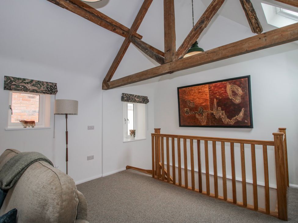 A living room with wooden beams and art on the wall at The Old China Shop in Ludlow
