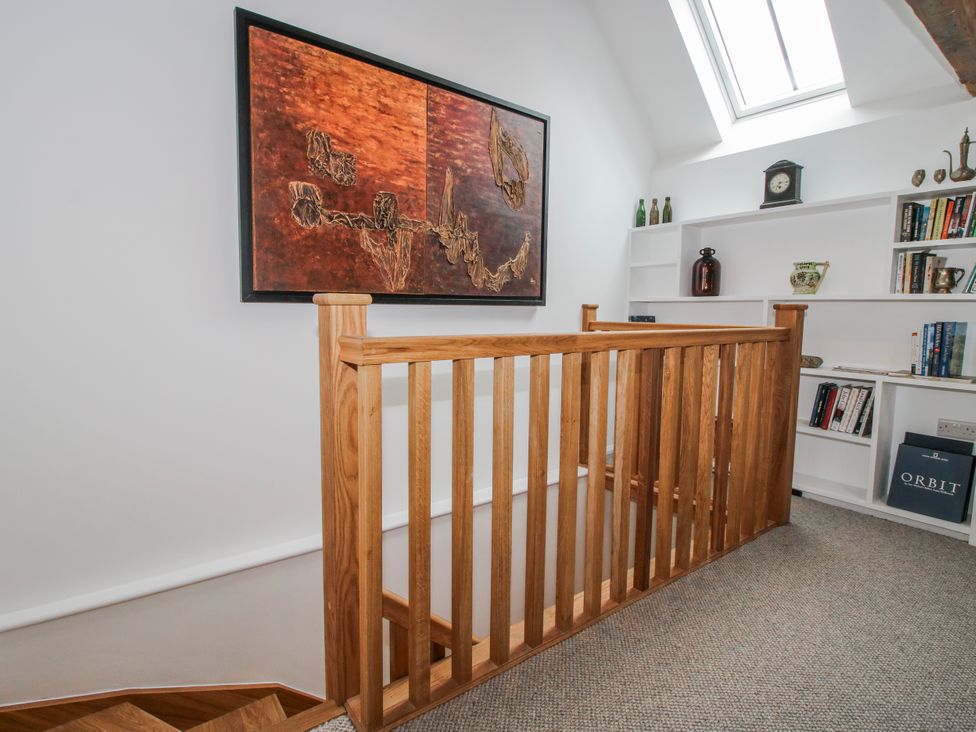 A staircase with wooden railing and wall art at The Old China Shop in Ludlow