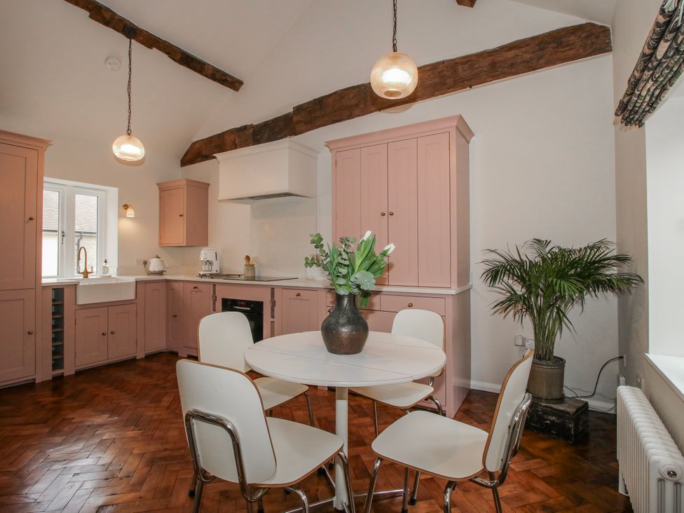 A kitchen with pink cabinets and a round table at The Old China Shop in Ludlow