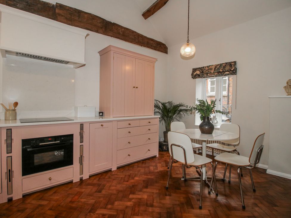 A kitchen with cabinets and a dining table at The Old China Shop in Ludlow
