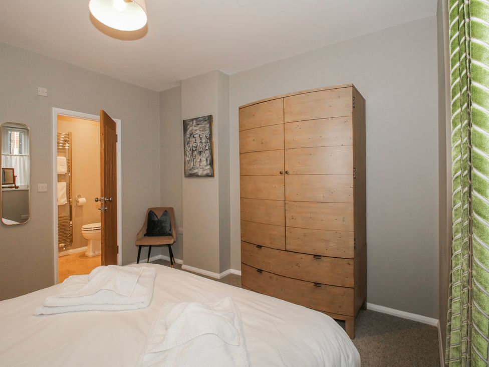 A bedroom with a bed and wardrobe at The Old China Shop in Ludlow