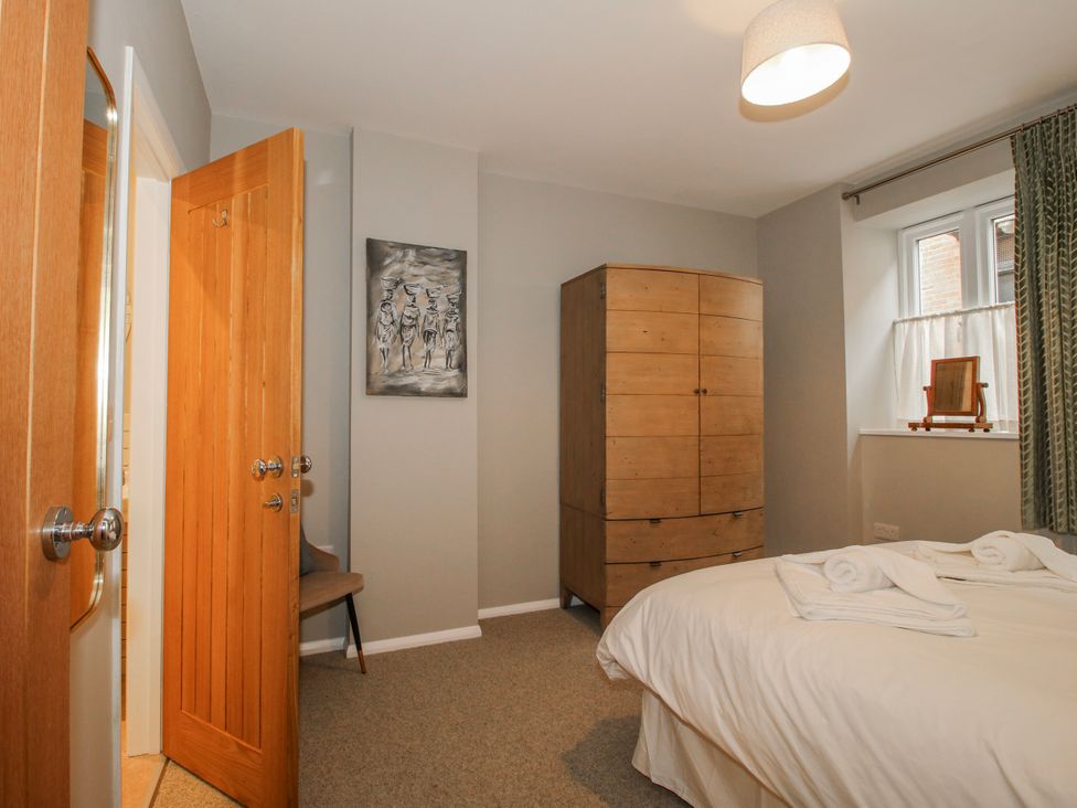 A bedroom with a bed and wardrobe at The Old China Shop in Ludlow