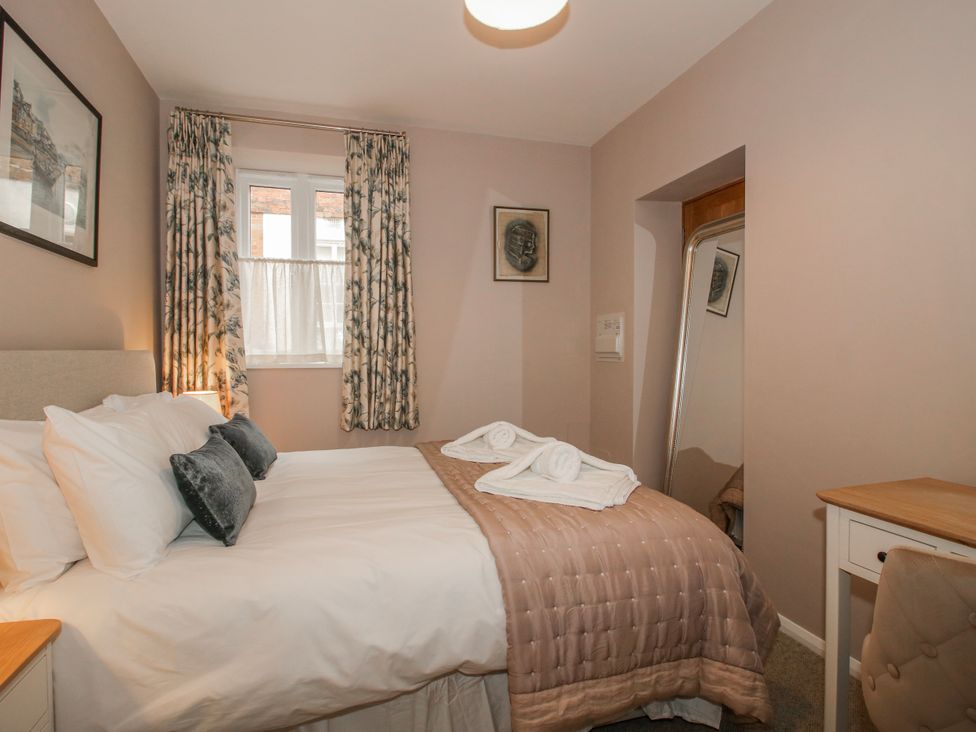 A bedroom with a bed and mirror at The Old China Shop in Ludlow