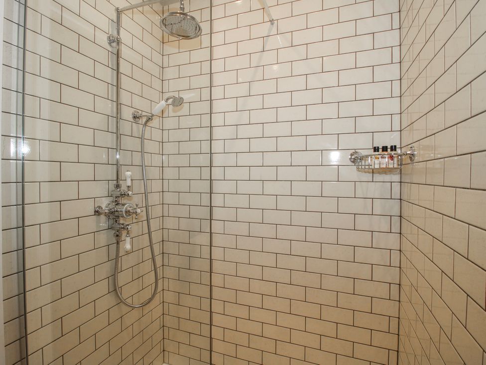A shower with tiled walls at The Old China Shop in Ludlow