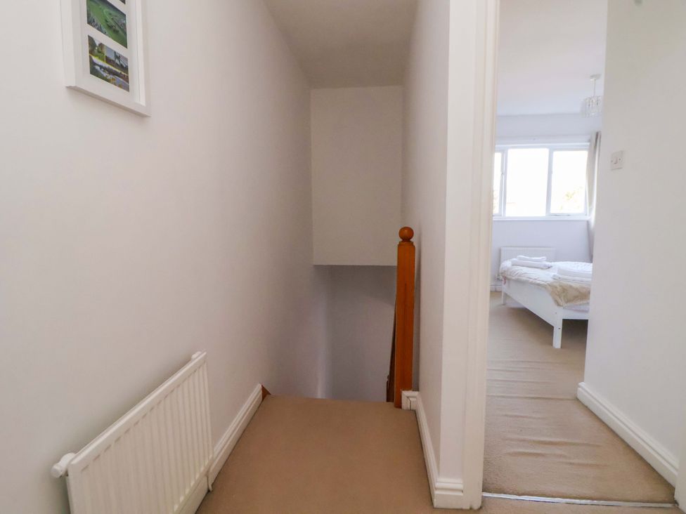 A hallway with a staircase and a radiator at 10 Church Walks Chester