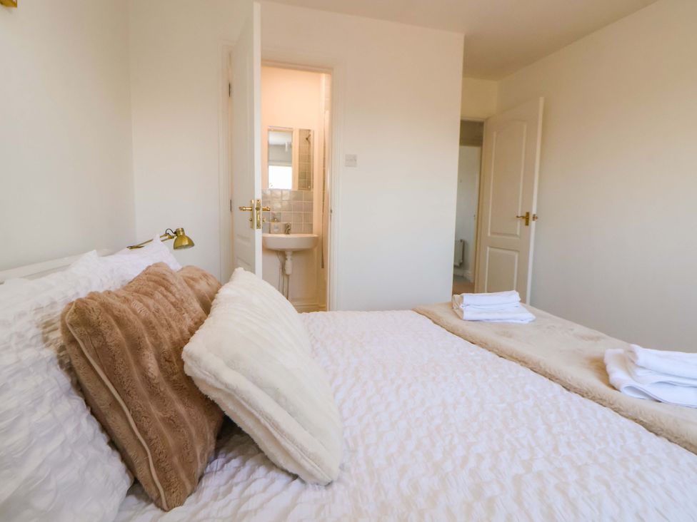 A bedroom with a bed and an open door leading to a bathroom at 10 Church Walks Chester
