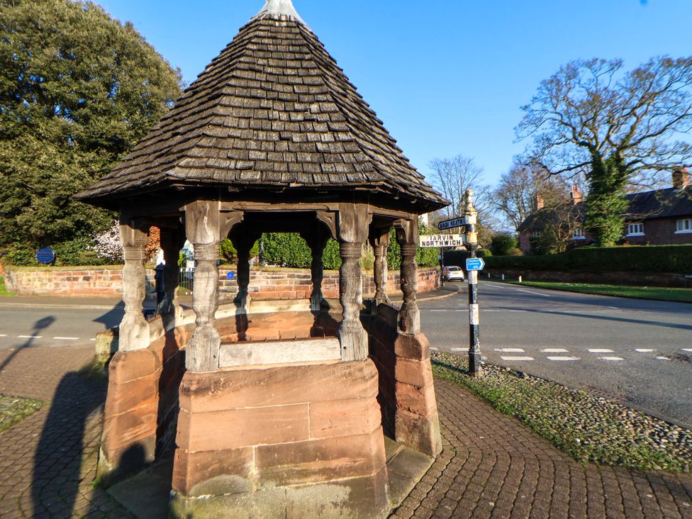 A gazebo with a thatched roof and stone base at 10 Church Walks Chester