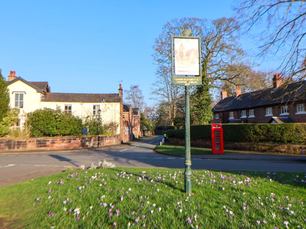 A road with houses and a signpost near flowers at 10 Church Walks Chester