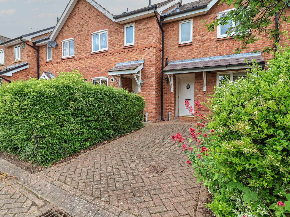 An outdoor view of a house with a pathway and bushes at 10 Church Walks in Christleton