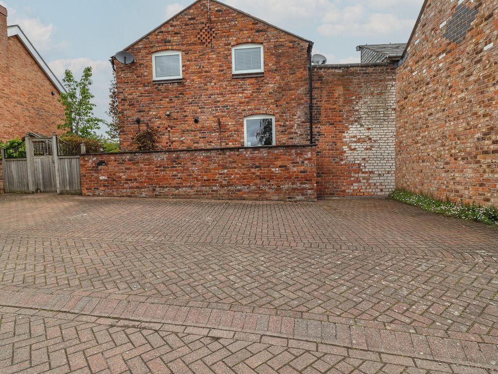 A paved outdoor area with a brick wall and plants at 10 Church Walks in Christleton