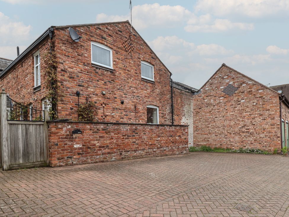 An outdoor view of a brick building and paved area at 10 Church Walks in Christleton