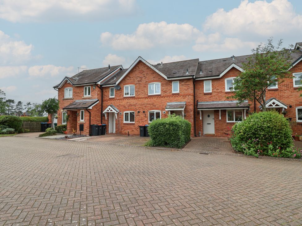 A row of houses with a driveway and bushes at 10 Church Walks in Christleton