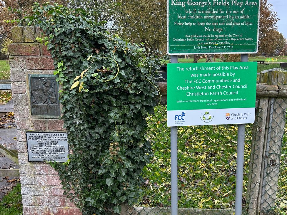 A play area sign and information plaque at King George's Fields in Christleton