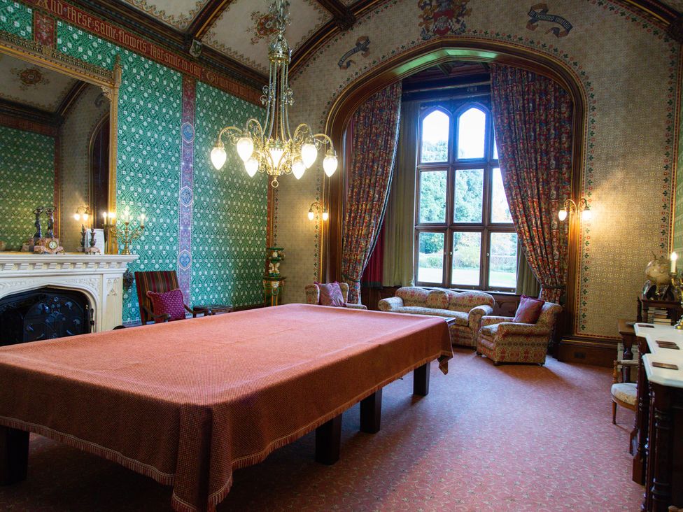 A dining room with a large table and sofa at Uphill Manor in Uphill near Weston-Super-Mare