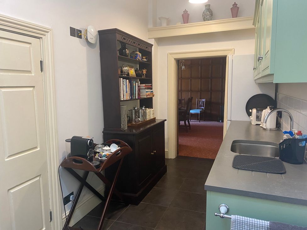 A kitchen with a coffee machine and a bookshelf at Uphill Manor Uphill near Weston-Super-Mare