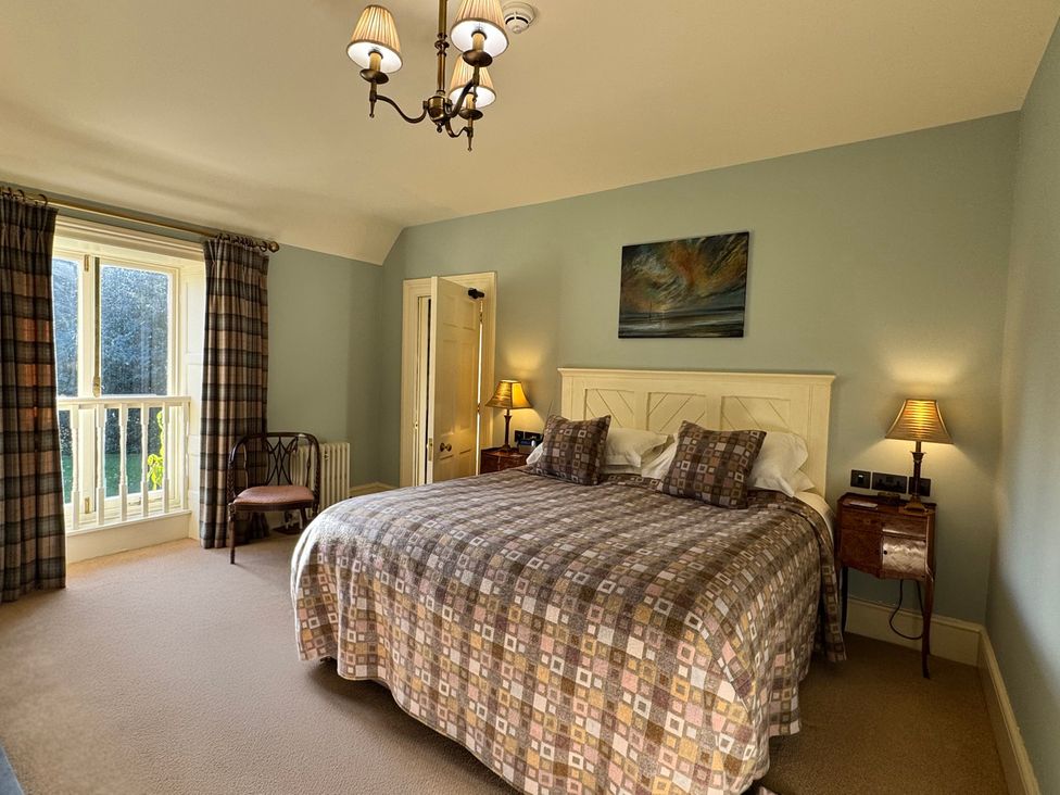 A bedroom with a bed and window at Uphill Manor in Uphill near Weston-Super-Mare
