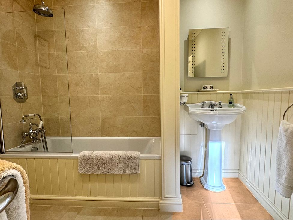 A bathroom with a bathtub and sink at Uphill Manor Uphill near Weston-Super-Mare
