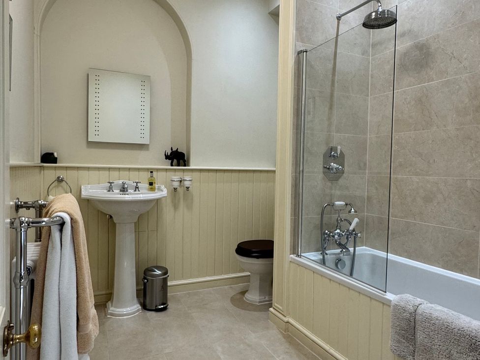 A bathroom with a bathtub, sink, and toilet at Uphill Manor in Uphill near Weston-Super-Mare