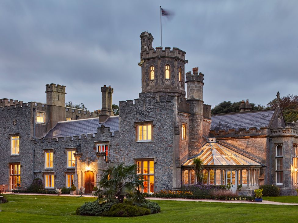An outdoor view of a castle with a conservatory at Uphill Manor Uphill near Weston-Super-Mare