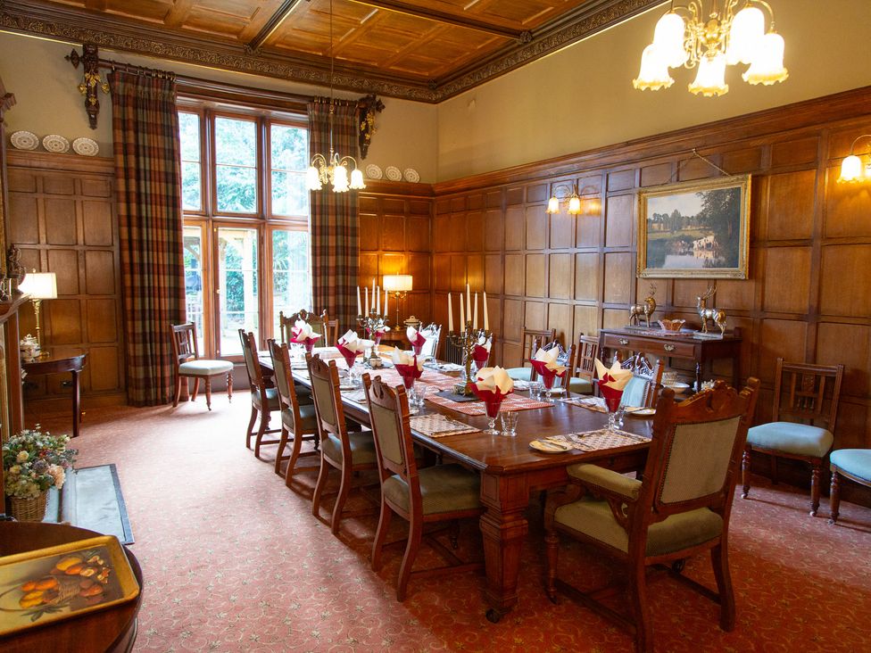A dining room with a large table set for dinner at Uphill Manor Uphill near Weston-Super-Mare