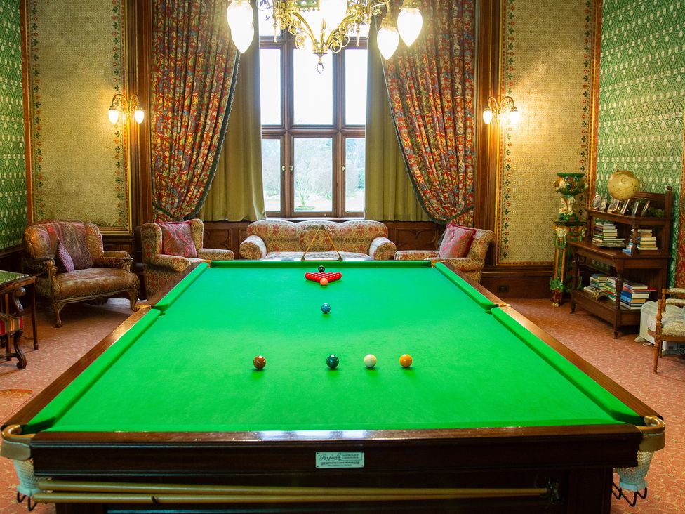A game room with a snooker table and seating at Uphill Manor in Uphill near Weston-Super-Mare