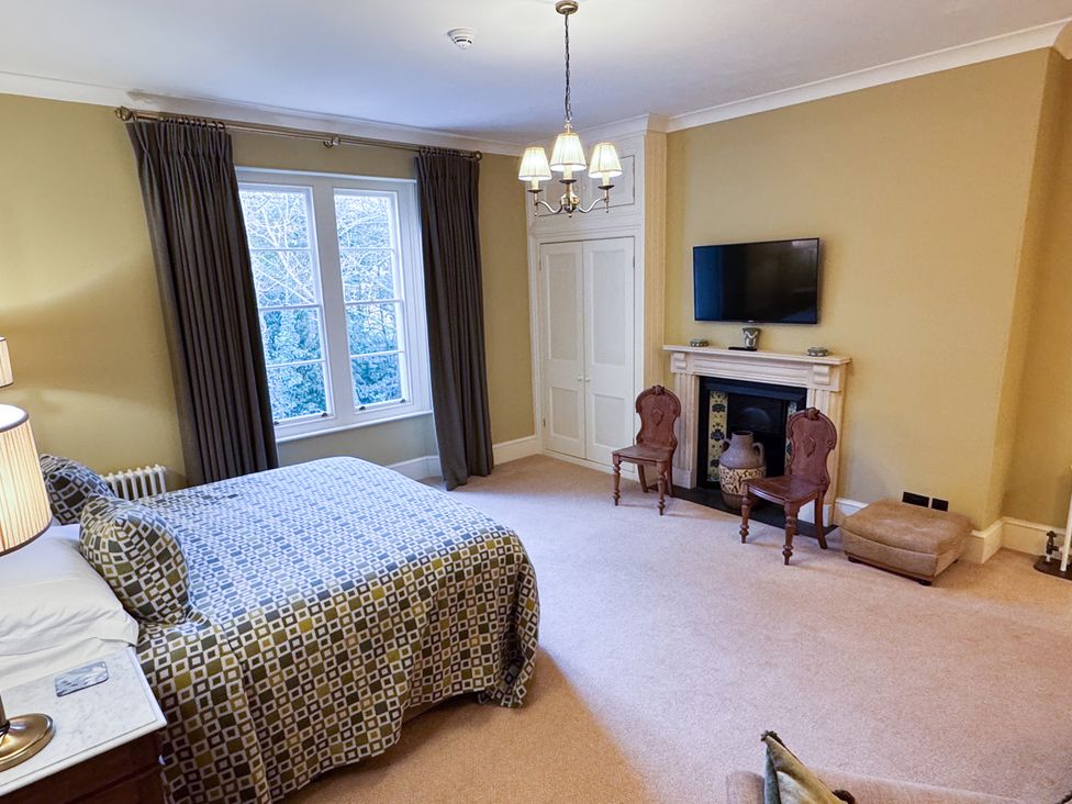 A bedroom with a bed and television at Uphill Manor in Uphill near Weston-Super-Mare