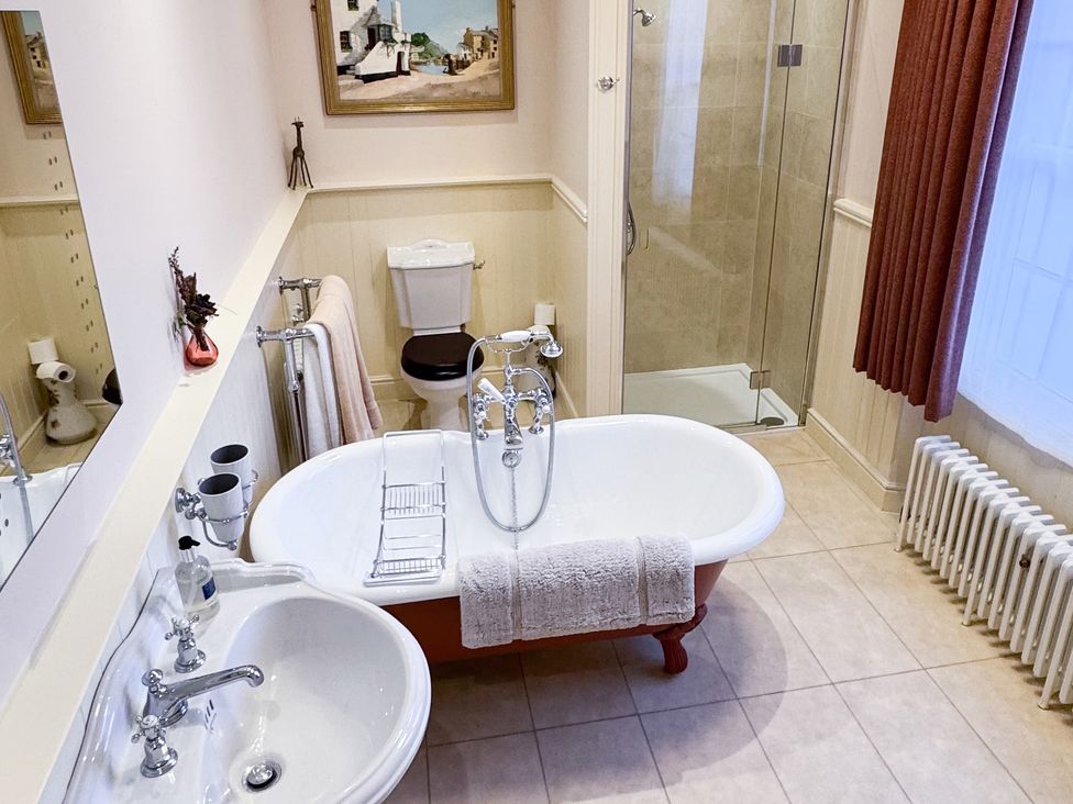 A bathroom with a bathtub, toilet, sink, and shower at Uphill Manor Uphill near Weston-Super-Mare