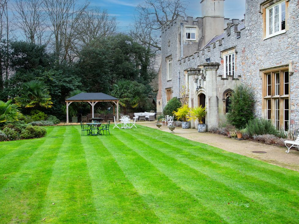 A garden with a gazebo and seating area at Uphill Manor in Uphill near Weston-Super-Mare