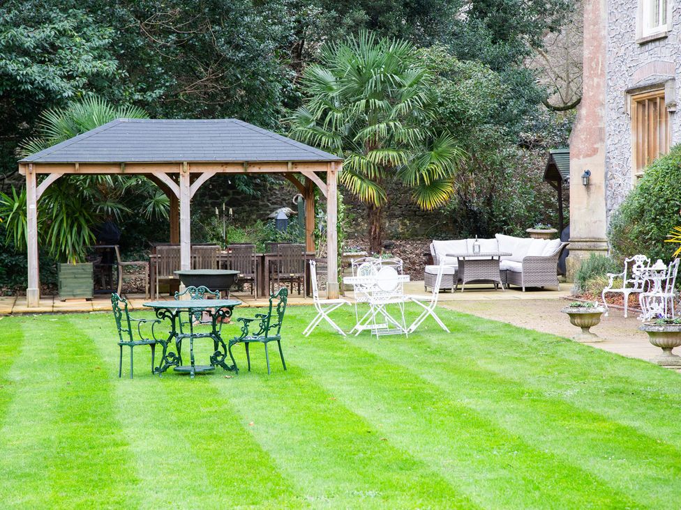 A garden with a gazebo and seating area at Uphill Manor in Uphill near Weston-Super-Mare