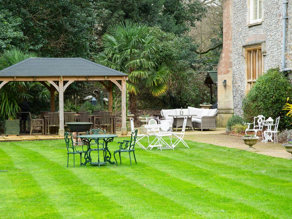 A garden with a gazebo and seating areas at Uphill Manor Uphill near Weston-Super-Mare