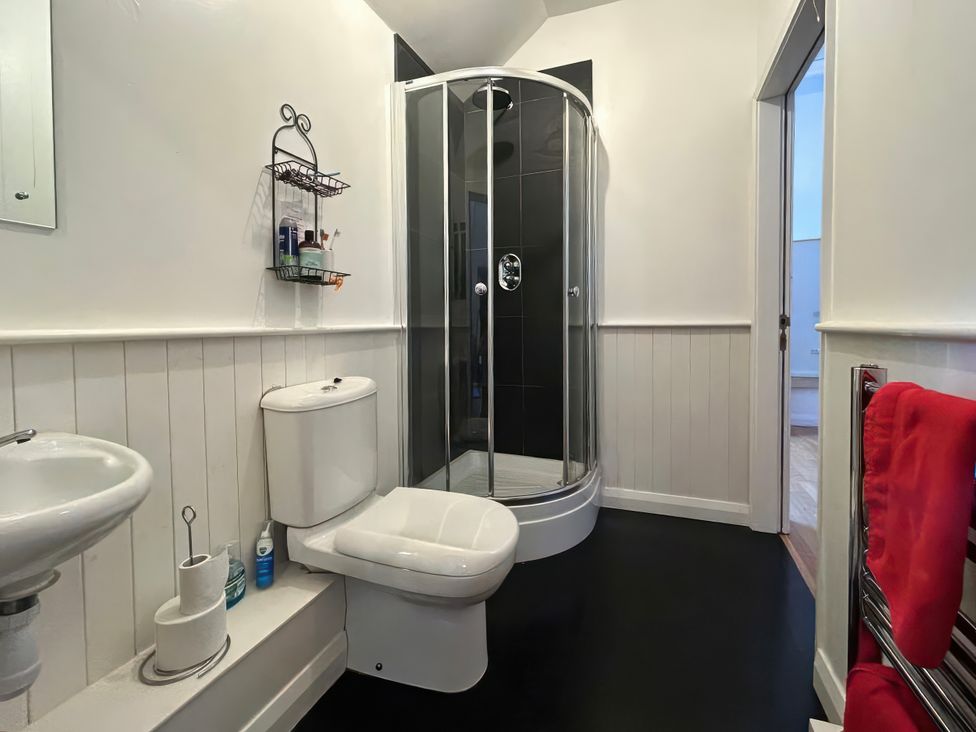 A bathroom with a shower toilet and wash basin at Too Hoots in Lligwy