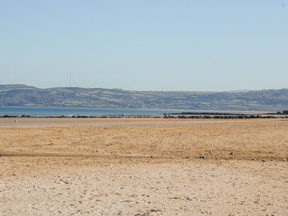 A beach with sand and water at Too Hoots in Lligwy