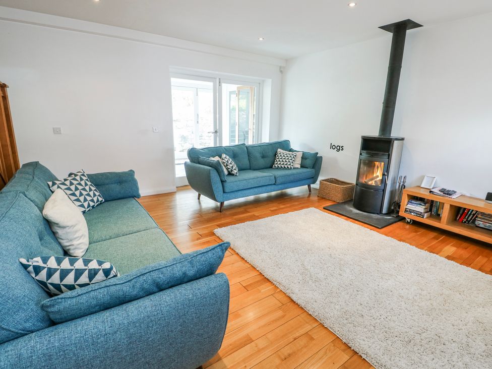 A living room with two sofas and a fireplace at Too Hoots in Lligwy